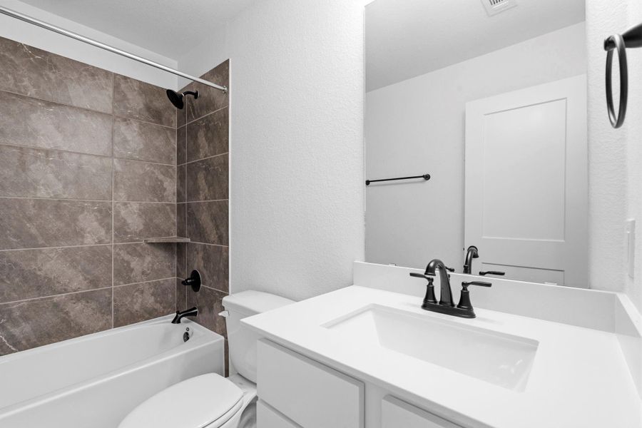 The secondary bathroom offers a clean, functional layout with modern fixtures and durable finishes designed for everyday use.