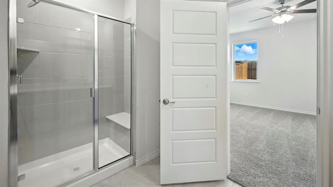 Walk-in shower with clear glass enclosure and integrated bench seating