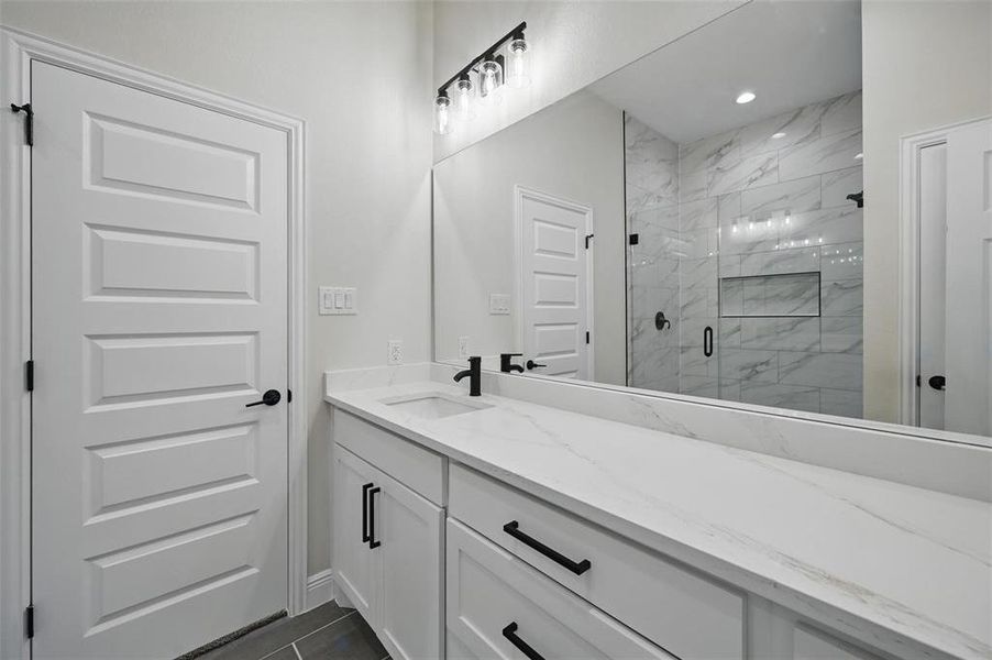 Bathroom featuring a marble finish shower and vanity Bathroom featuring a marble finish shower and vanity