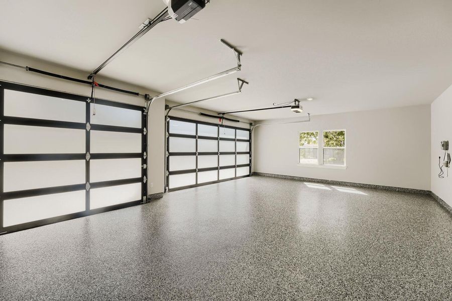 Ample vehicle storage is provided by a spacious garage with contemporary doors and a gleaming epoxy floor. Ample vehicle storage is provided by a spacious garage with contemporary doors and a gleaming epoxy floor.