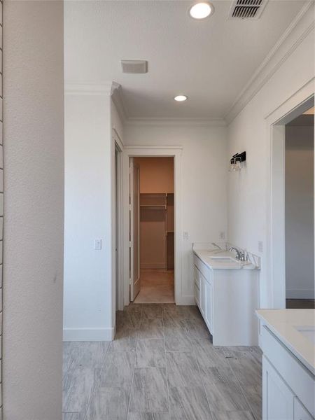 Master Bathroom with Seperate His and Hers vanities, tile patterned floors, and crown molding. View From Master Shower Side.