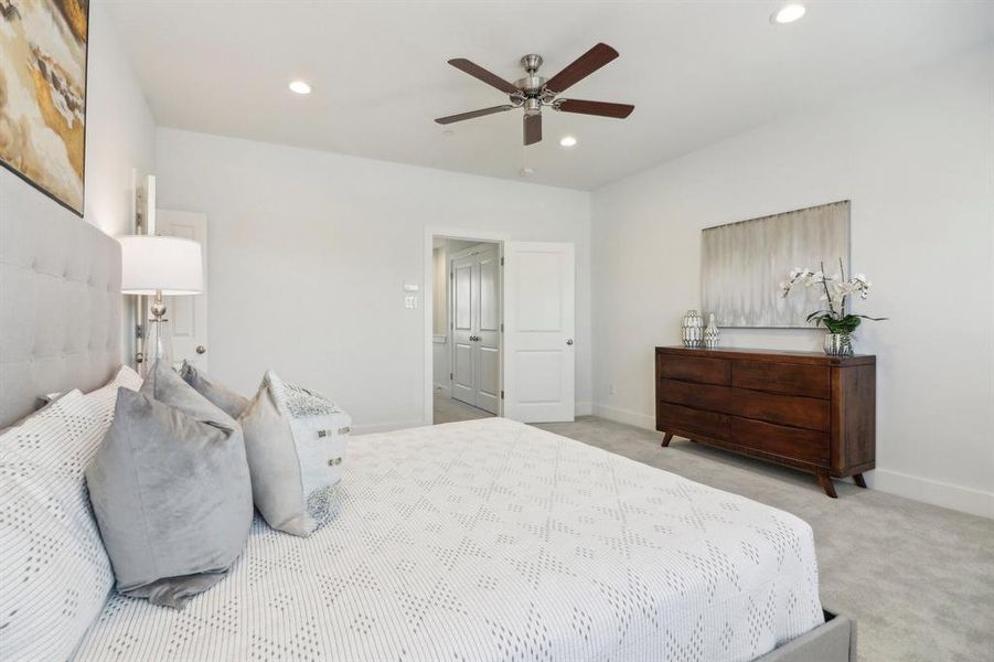 Bedroom with ceiling fan and light carpet