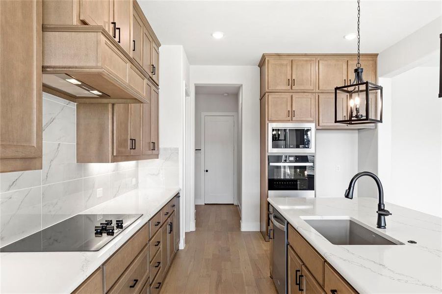 Custom vented hood with beautiful wood cabinets. Notice the double ovens in the background.