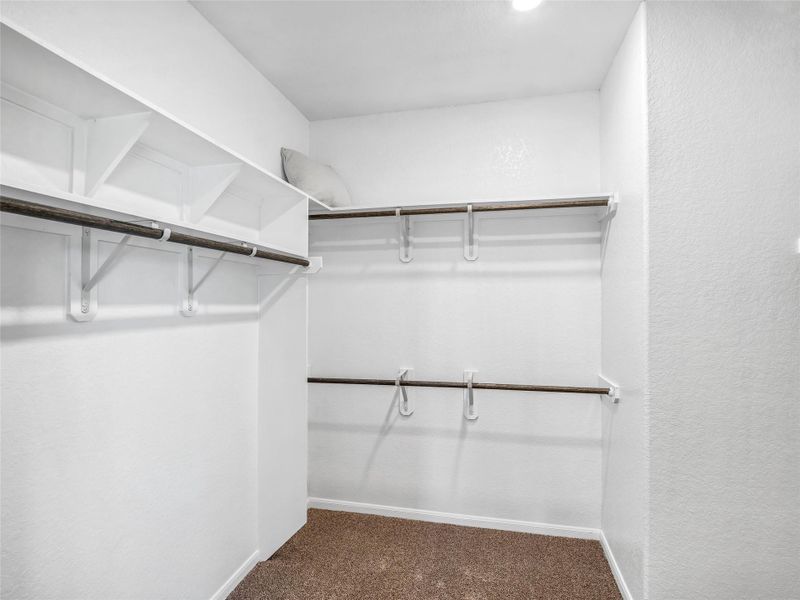 Walk-in closet that epitomizes luxury and practicality. This generously sized space features built-in shelving, offering abundant room for impeccable organization. High ceilings and recessed lighting create a bright and welcoming ambiance. Sample photo of completed home with similar floor plan. Actual colors and selections may vary. Walk-in closet that epitomizes luxury and practicality. This generously sized space features built-in shelving, offering abundant room for impeccable organization. High ceilings and recessed lighting create a bright and welcoming ambiance. Sample photo of completed home with similar floor plan. Actual colors and selections may vary.