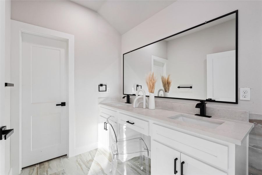 This spa-inspired bathroom makes everyday routines feel elevated with a sleek double vanity and modern finishes throughout. The oversized mirror and clean design create a bright, polished space that feels both luxurious and functional.