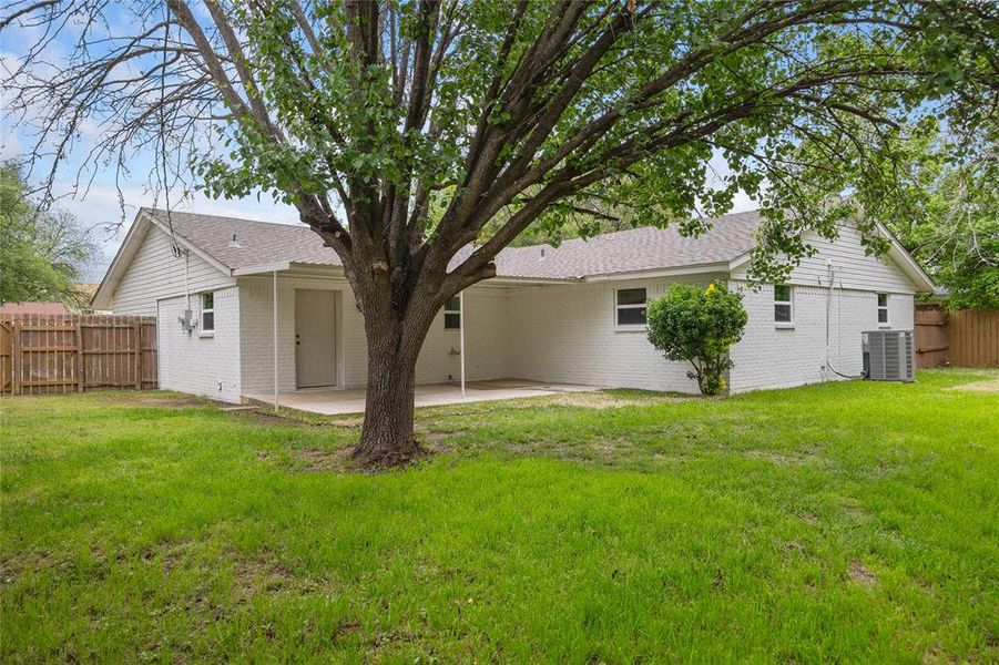 Back of property featuring central AC unit, fence, a yard, a patio area, and brick siding Back of property featuring central AC unit, fence, a yard, a patio area, and brick siding