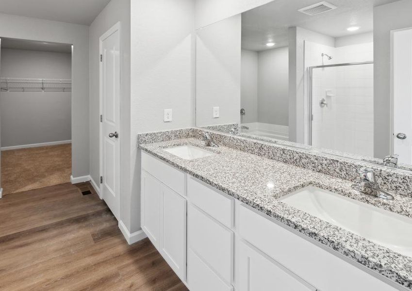 Luxurious master bathroom with a double-sink vanity and separate tub and shower.