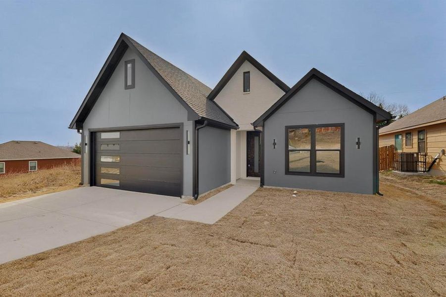 View of front of property with driveway, stucco siding, and a garage View of front of property with driveway, stucco siding, and a garage