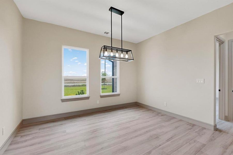 Unfurnished dining area with light wood-style floors and a chandelier Unfurnished dining area with light wood-style floors and a chandelier