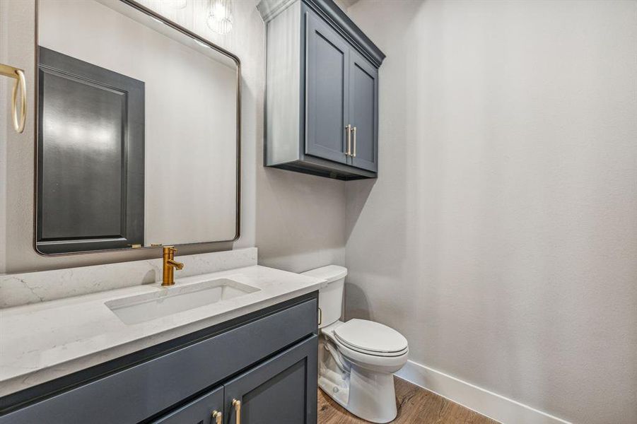 Bathroom with toilet, hardwood / wood-style floors, and vanity