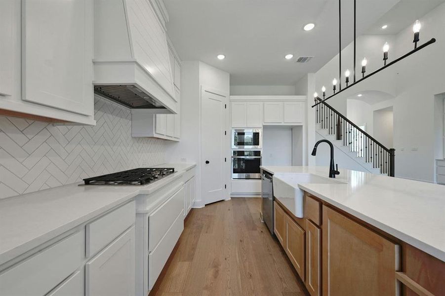 Kitchen featuring white cabinetry, light wood-style floors, light stone counters, stainless steel appliances, and recessed lighting Kitchen featuring white cabinetry, light wood-style floors, light stone counters, stainless steel appliances, and recessed lighting