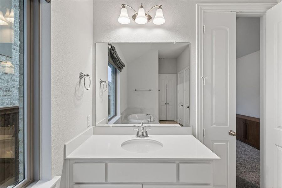 Bathroom with a garden tub and a textured wall Bathroom with a garden tub and a textured wall