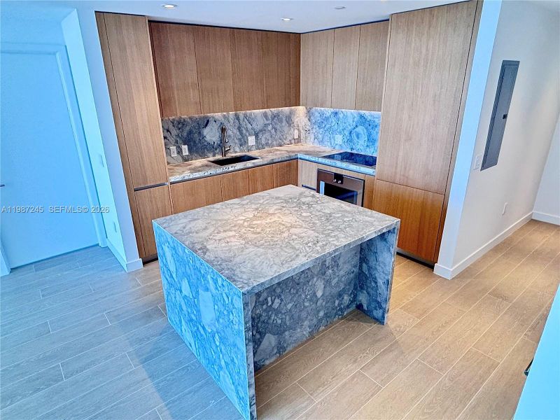 Kitchen with custom island with matching ItalKraft cabinetry and quartzite waterfall Kitchen with custom island with matching ItalKraft cabinetry and quartzite waterfall