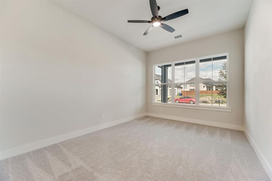 Unfurnished room with light colored carpet and ceiling fan Unfurnished room with light colored carpet and ceiling fan