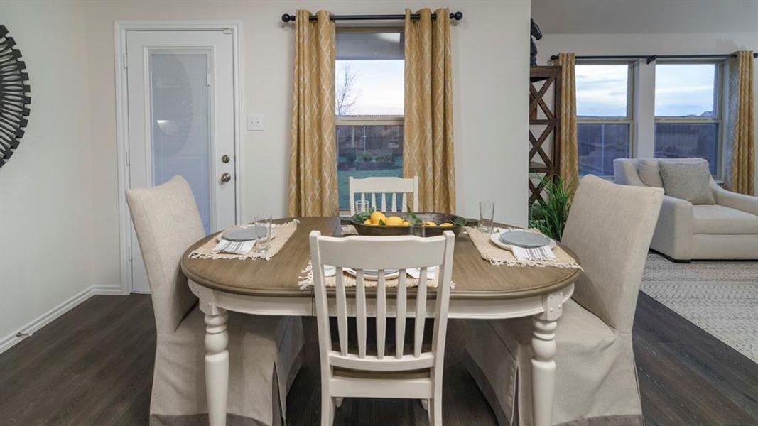 Dining room featuring dark wood-style floors and baseboards