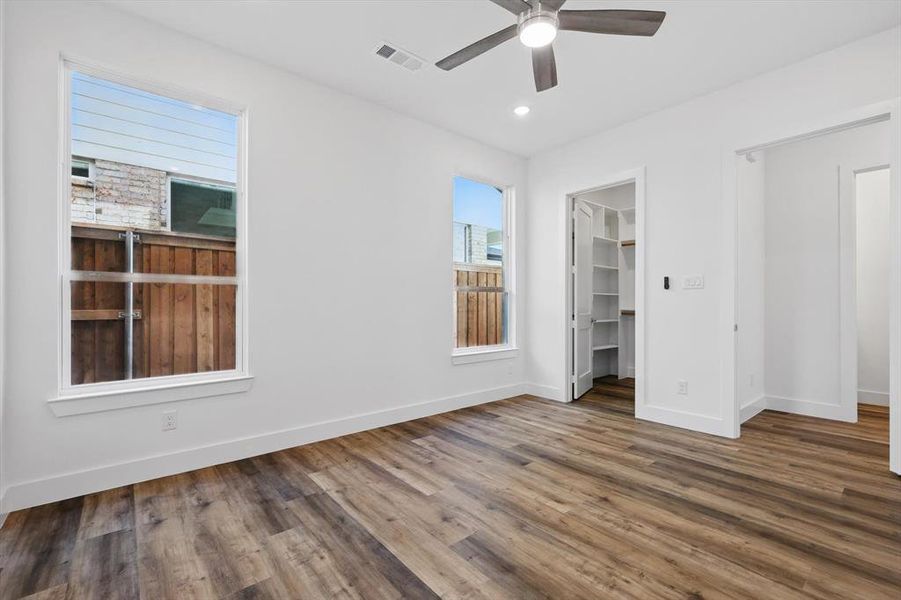 Unfurnished bedroom featuring recessed lighting, wood finished floors, visible vents, baseboards, and a spacious closet