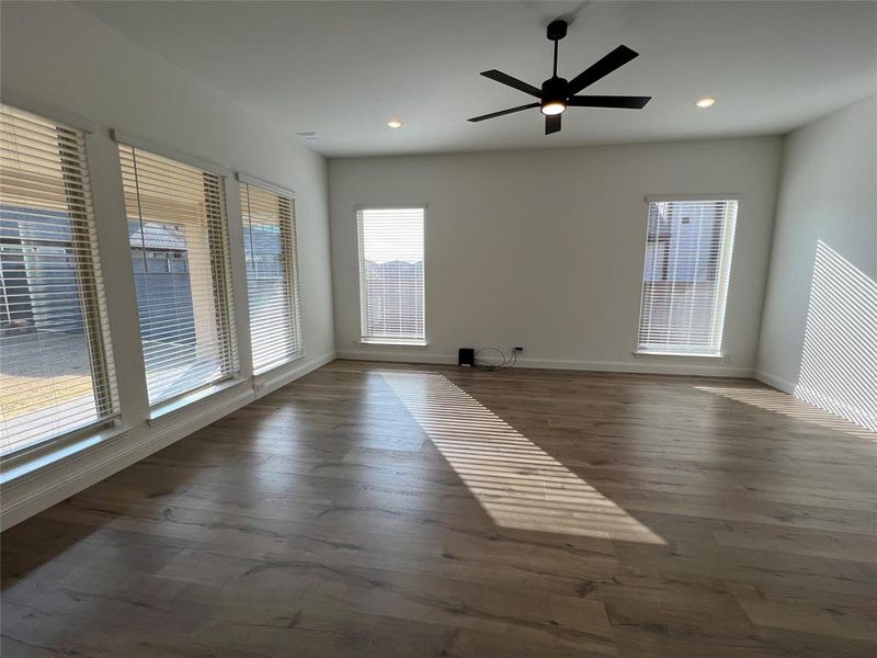 Spacious family room with ceiling fan, dark wood-style flooring, and recessed lighting Spacious family room with ceiling fan, dark wood-style flooring, and recessed lighting