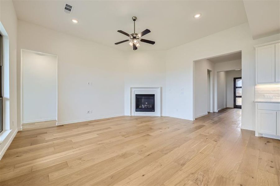 Unfurnished living room featuring ceiling fan and light hardwood / wood-style flooring