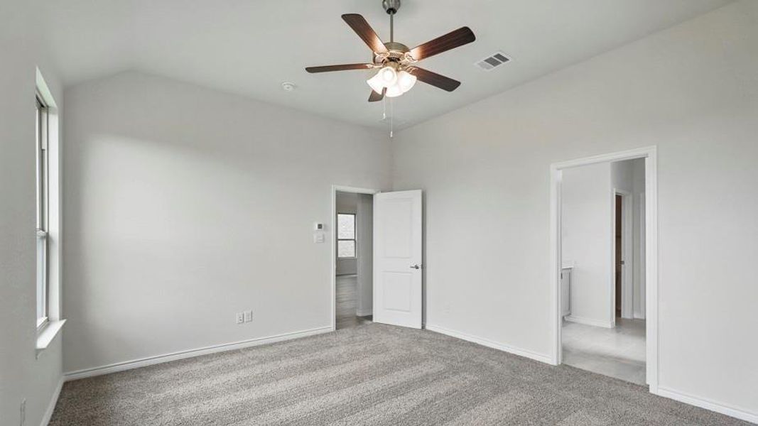 Unfurnished bedroom with light colored carpet, ceiling fan, and lofted ceiling