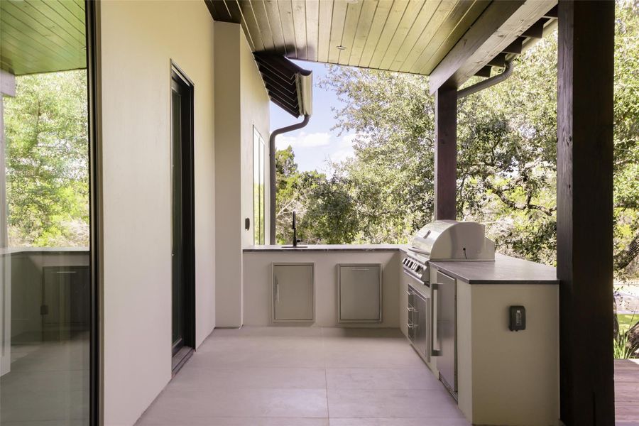 The dedicated outdoor kitchen is a chef’s dream, fully equipped with Blaze appliances and stunning leathered Black Forest quartz countertops. Whether you’re hosting a summer barbecue or prepping dinner while the everyone is swimming, this setup makes outdoor entertaining effortless.