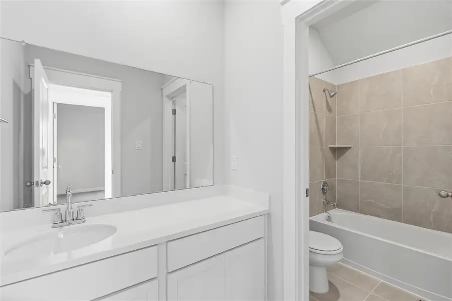 Bathroom with bathing tub / shower combination, vanity, and light tile patterned floors