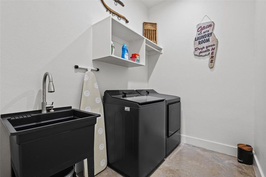 Laundry room featuring washing machine and dryer and baseboards