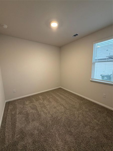 Empty room featuring dark carpet and baseboards