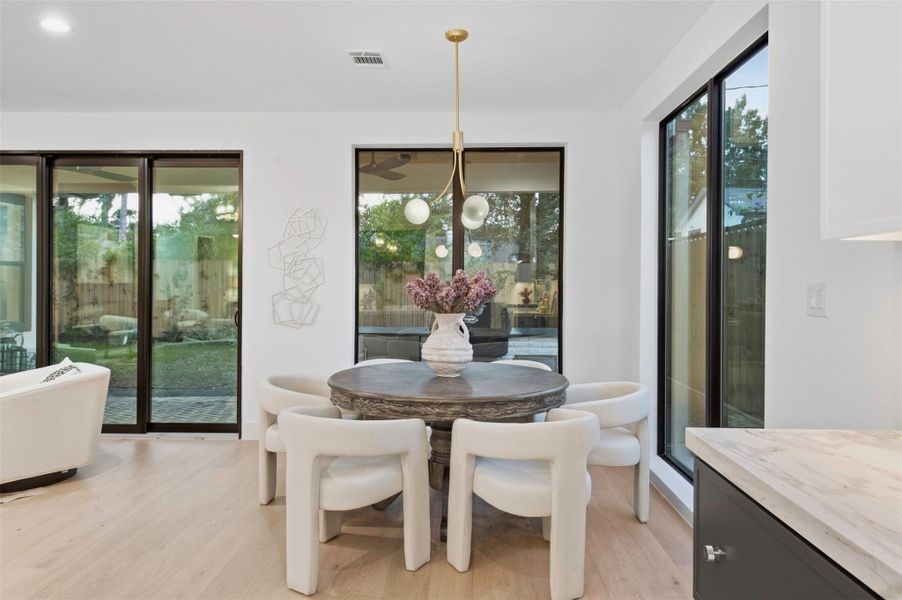 Floor-to-ceiling corner windows flood the formal dining area with natural light while framing beautiful views of the backyard.
