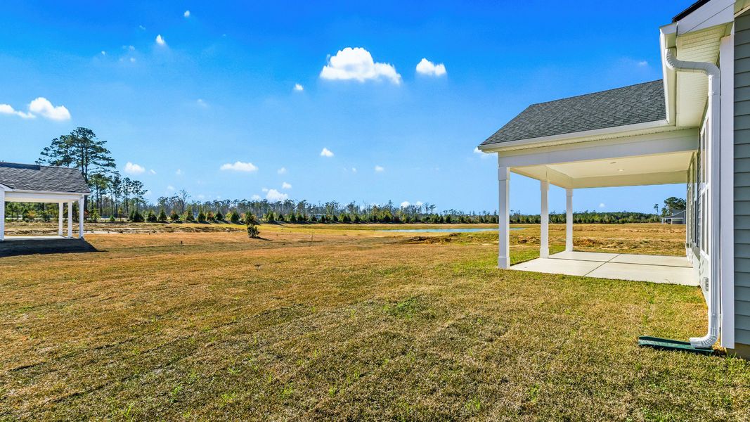 A peaceful Easton backyard featuring a covered porch and scenic pond views A peaceful Easton backyard featuring a covered porch and scenic pond views