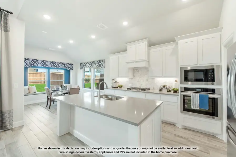 Kitchen with white cabinets, large center island, stainless steel appliances, and open view to dining area. Kitchen with white cabinets, large center island, stainless steel appliances, and open view to dining area.