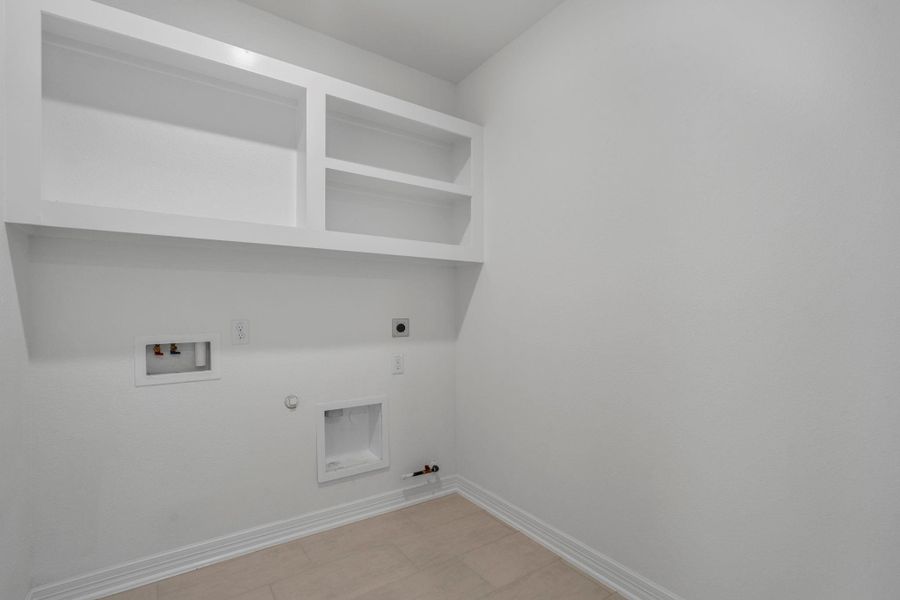 The laundry room layout is carefully planned for optimal workflow with designated areas for washing, drying, and storing.