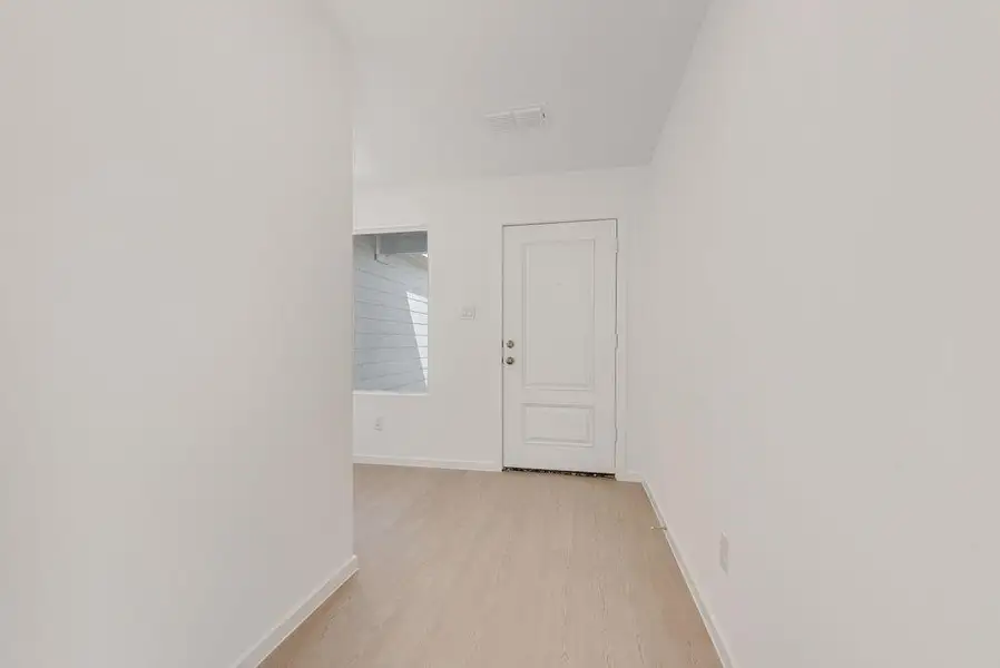 Empty room featuring baseboards and light wood-type flooring