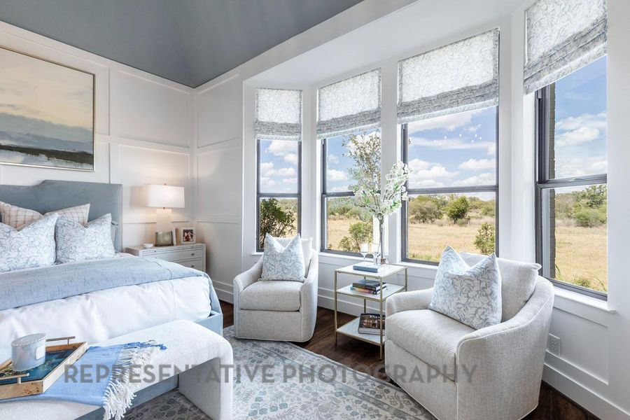 Bedroom featuring a decorative wall and wood finished floors Bedroom featuring a decorative wall and wood finished floors