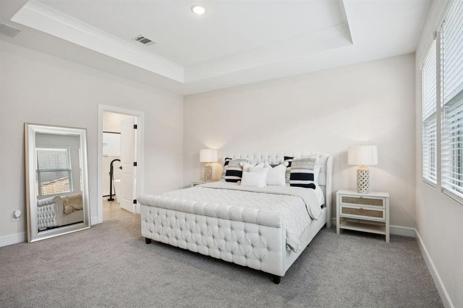 Spacious primary suite with tray ceiling, double walk-in closets, and a spa-inspired en suite bath. Spacious primary suite with tray ceiling, double walk-in closets, and a spa-inspired en suite bath.