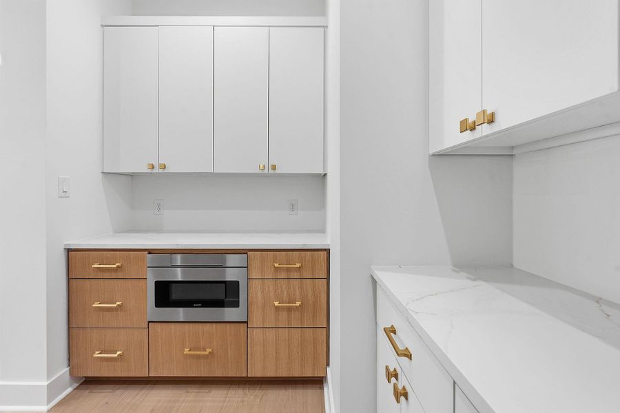 Modern cabinetry and countertops elevate this well-appointed butler pantry area.