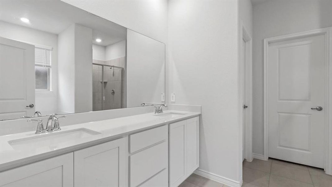 Bathroom featuring a shower stall, double vanity, light tile patterned floors, and recessed lighting Bathroom featuring a shower stall, double vanity, light tile patterned floors, and recessed lighting