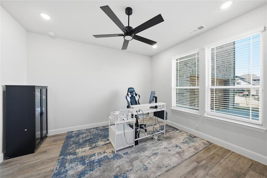 Office area with light wood-type flooring, a ceiling fan, and recessed lighting