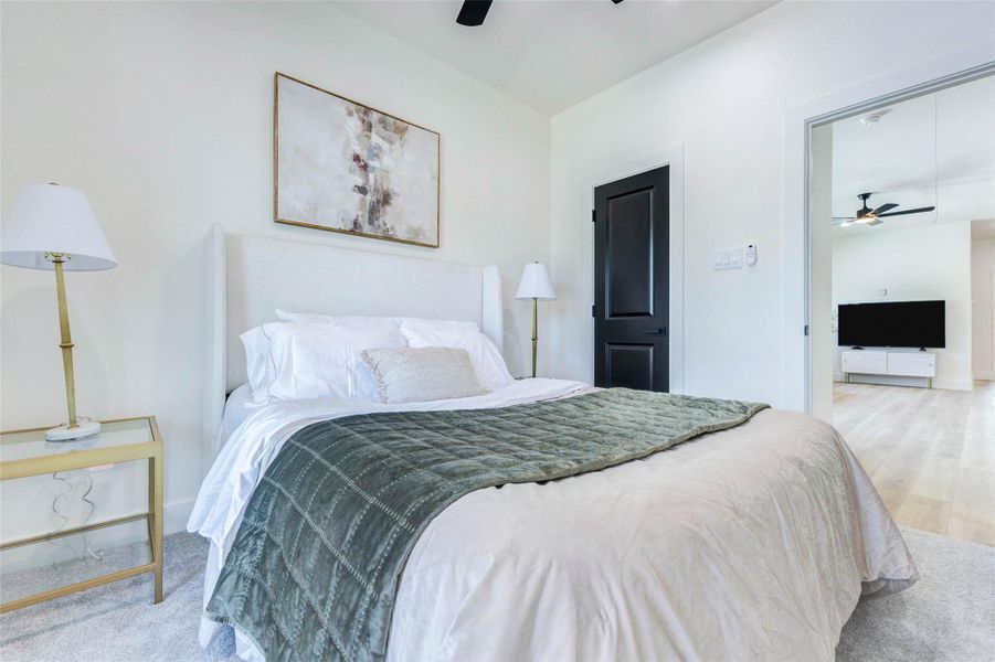 A spacious bedroom suite features high ceilings, clean white walls, and a streamlined layout that flows into the second-floor landing.