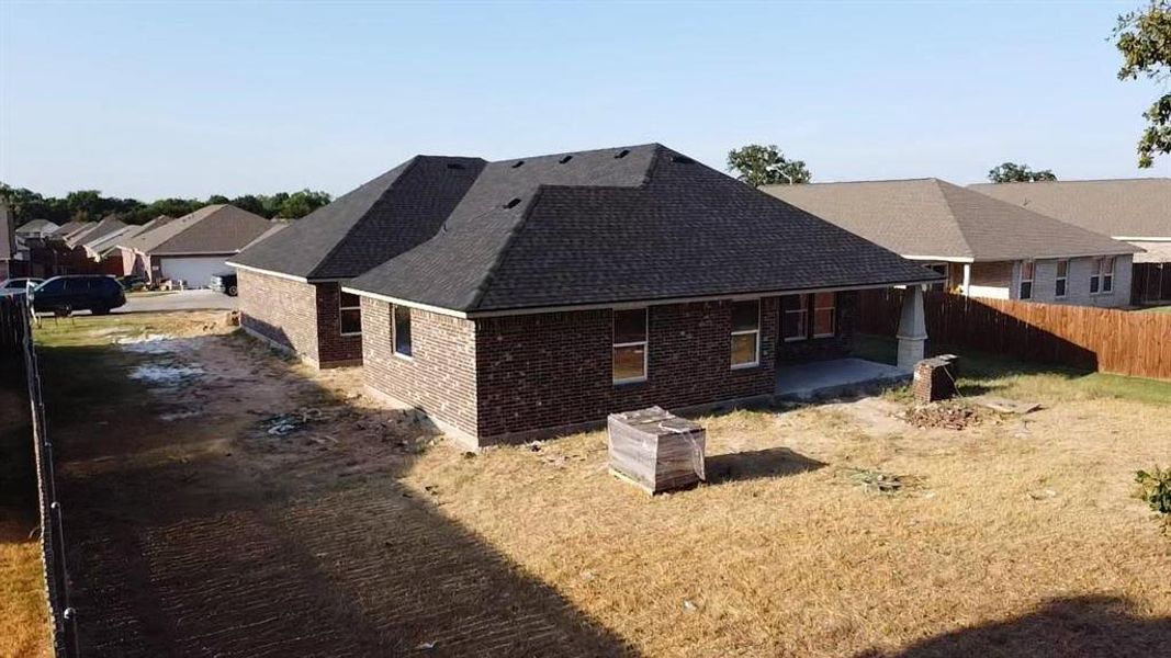 View of side of home with a lawn and a patio