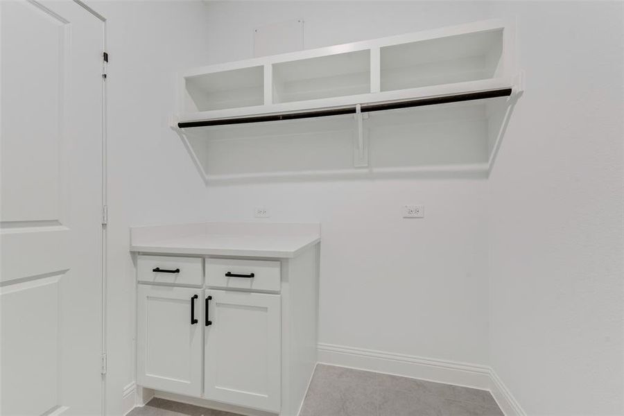 Laundry area featuring light tile patterned flooring