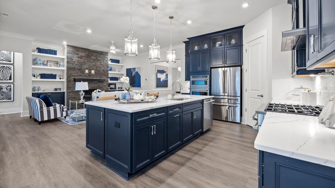 The Adventurer Plan by DBR Homes kitchen and living area with blue cabinets and modern features in Fort Mill, SC.