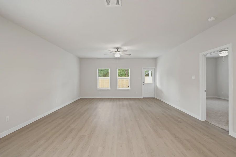 A room with a wood floor and a ceiling fan. A room with a wood floor and a ceiling fan.