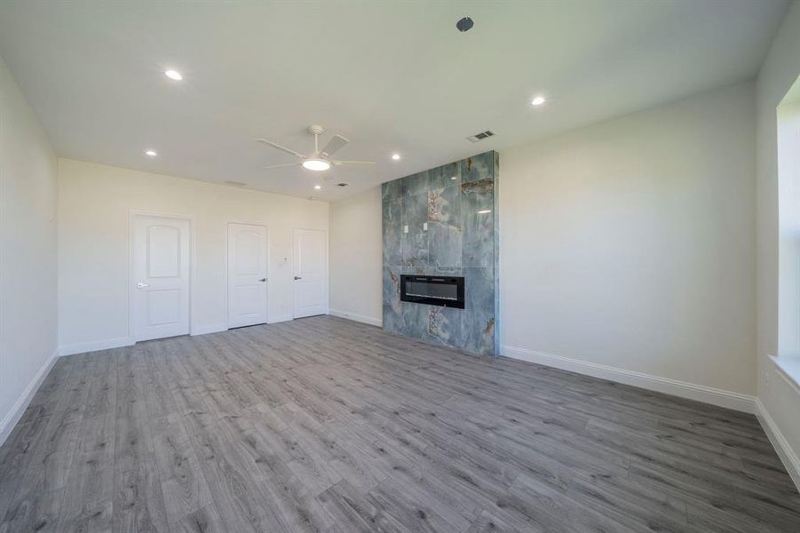 Unfurnished living room with wood finished floors, a fireplace, recessed lighting, and ceiling fan Unfurnished living room with wood finished floors, a fireplace, recessed lighting, and ceiling fan