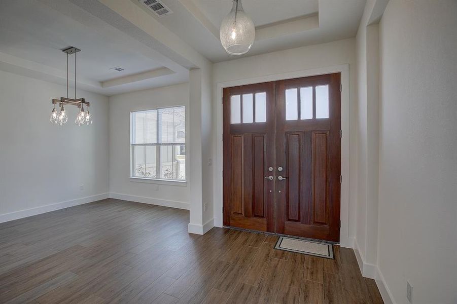 The formal dining area has a trey ceiling, and a modern Edison build light fixture