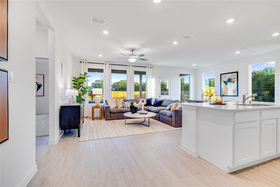 Living room with sink, ceiling fan, and light hardwood / wood-style flooring