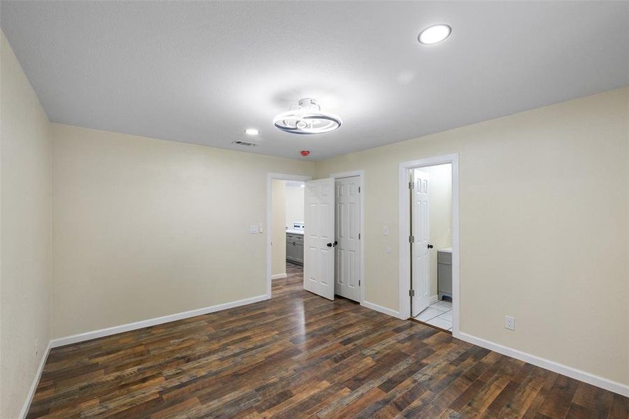 Unfurnished bedroom with hardwood / wood-style flooring and ensuite bath