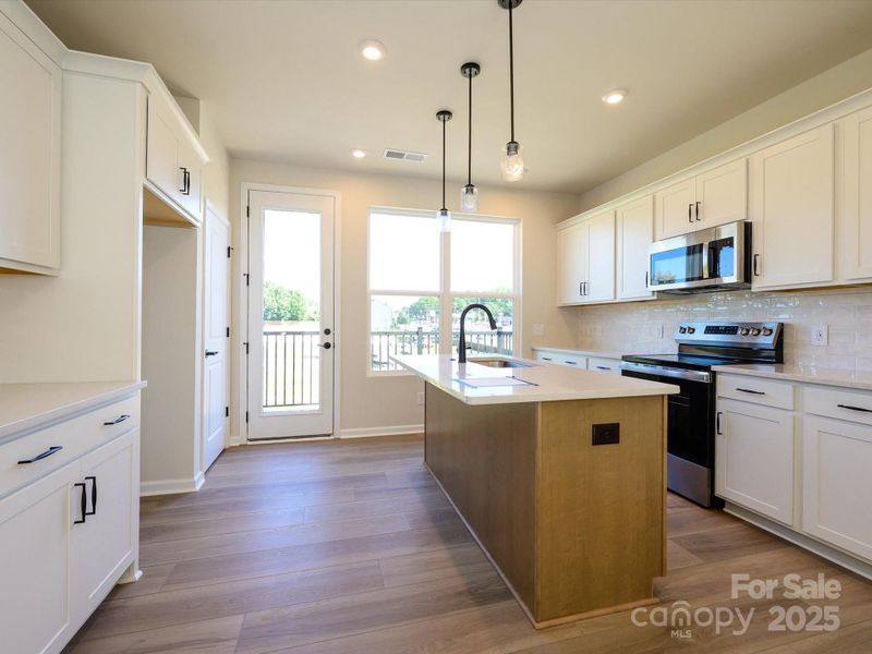 Leading to the outdoor living space, this kitchen is bathed in light.