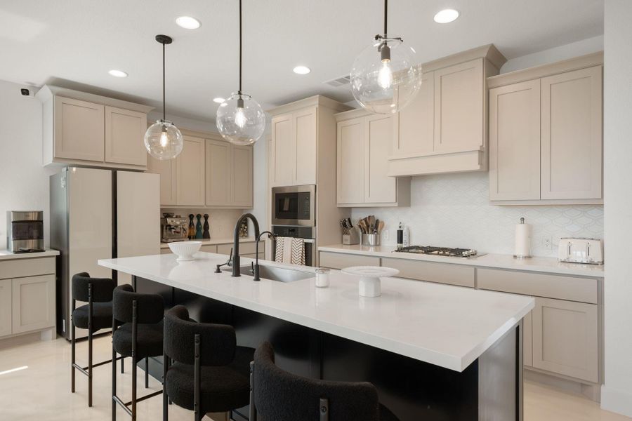Culinary delights await in this modern kitchen, featuring a spacious island with bar seating and integrated sink. Culinary delights await in this modern kitchen, featuring a spacious island with bar seating and integrated sink.