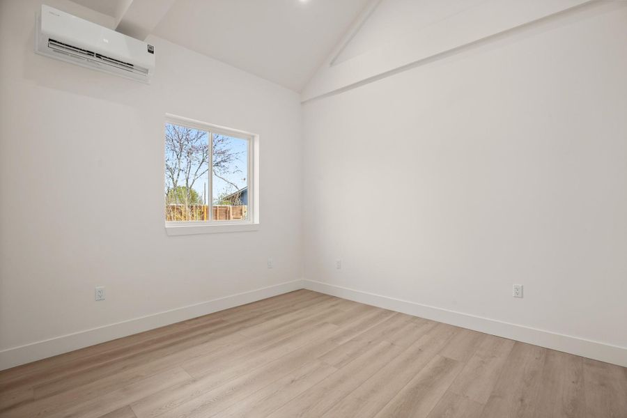 Spare room featuring vaulted ceiling and light wood finished floors