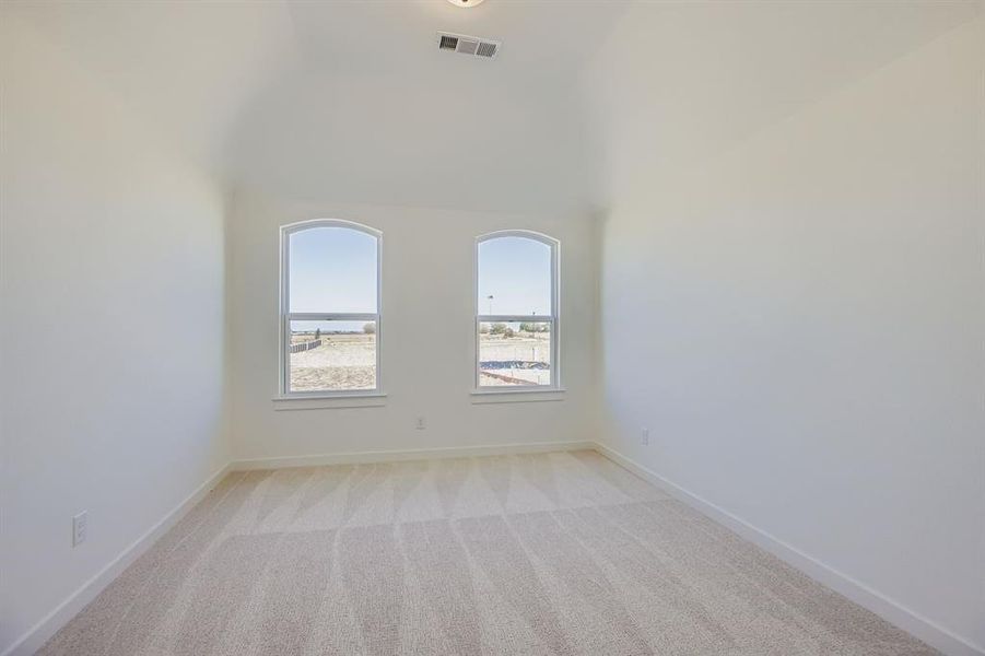 Unfurnished room featuring light carpet and high vaulted ceiling Unfurnished room featuring light carpet and high vaulted ceiling